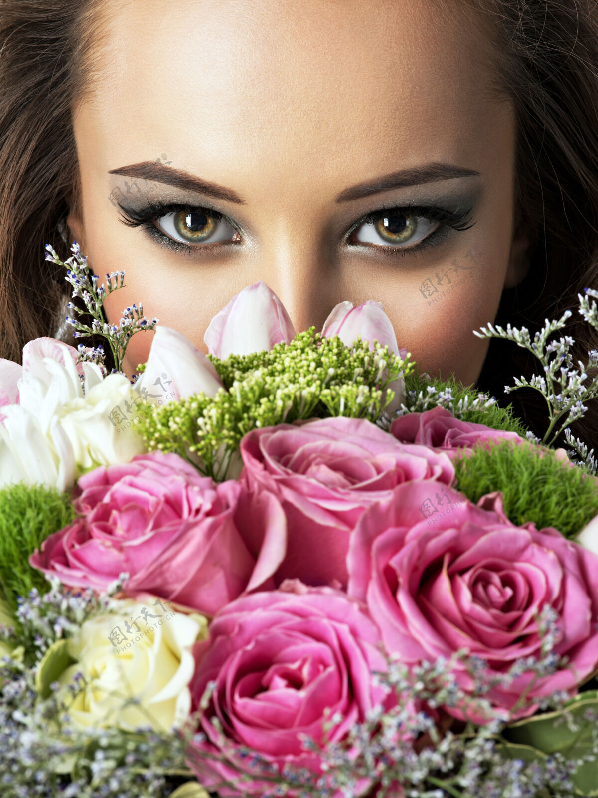 华丽美丽女孩的特写脸上摆满了鲜花年轻迷人的女人捧着春天的花束新鲜花束化妆品