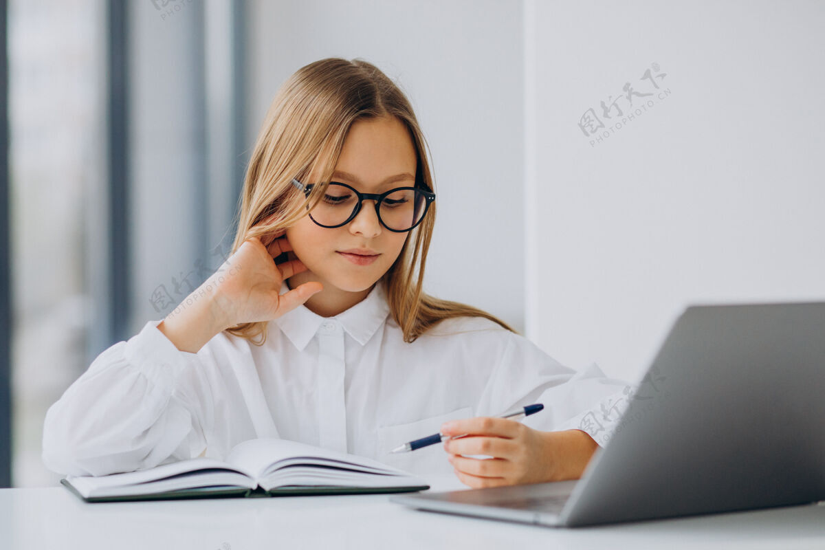 年轻可爱的女孩在家里用电脑学习智能现代小学生
