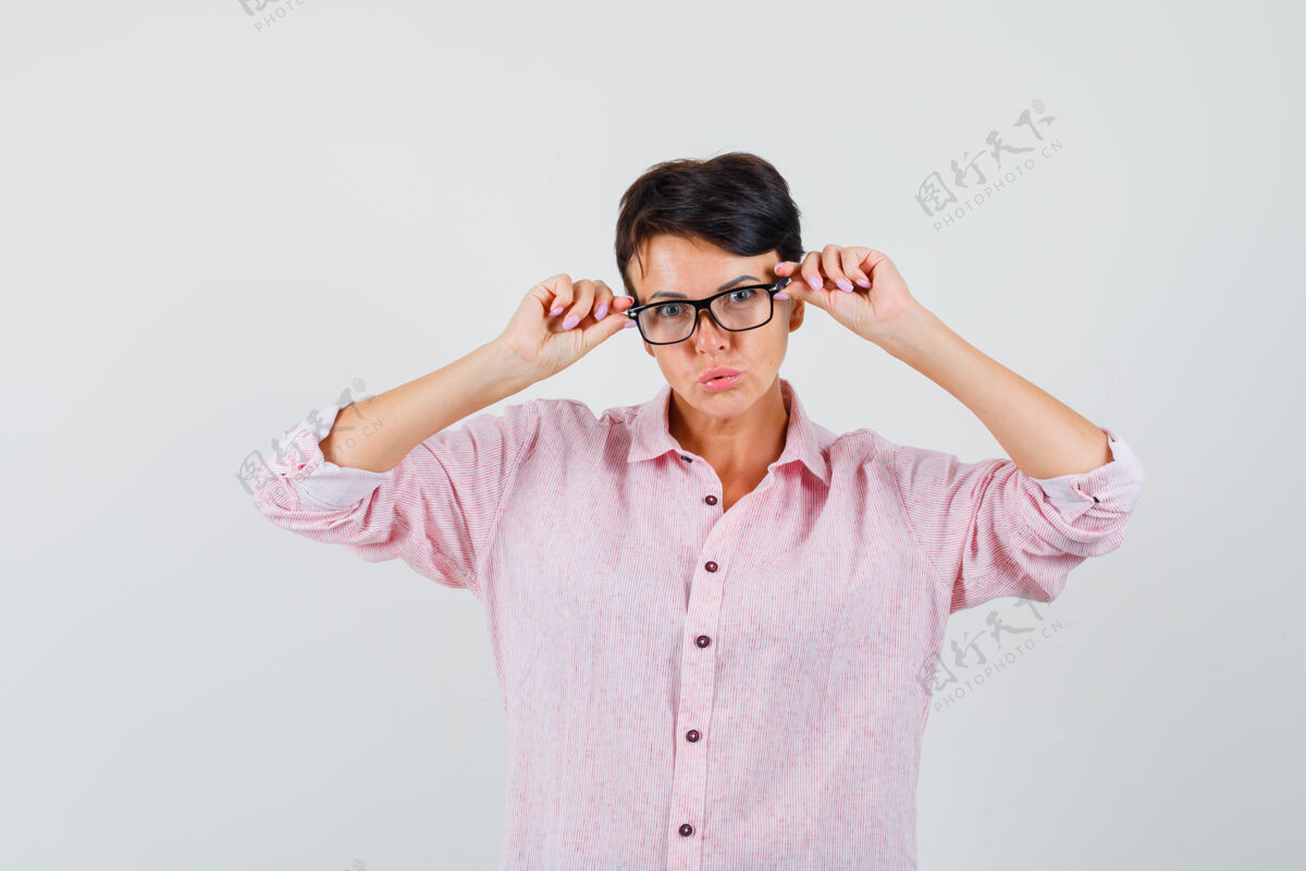 听看穿粉红色衬衫的女性透过眼镜看 看起来很聪明 前视图保护爆发肖像
