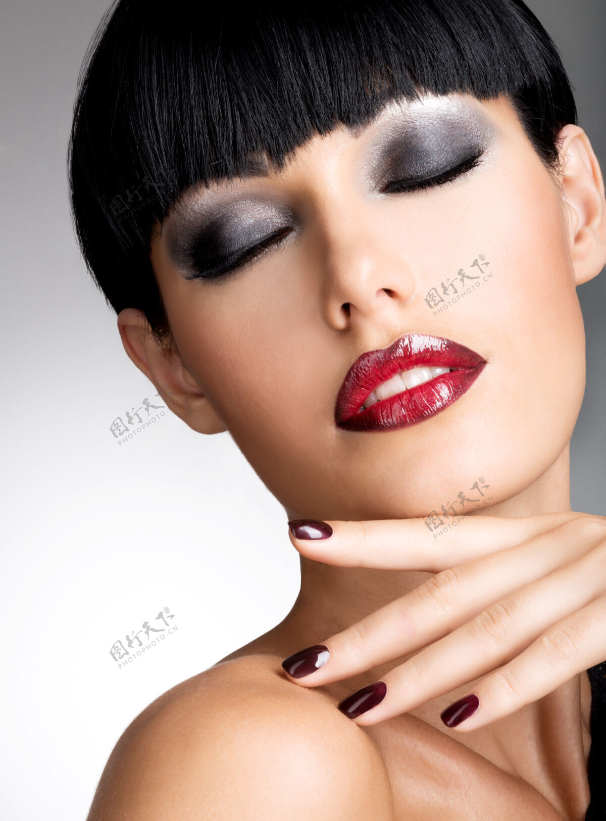 肖像一张长着漂亮黑指甲和性感红唇的女人的脸一头黑发的时尚模特漂亮姿势女人