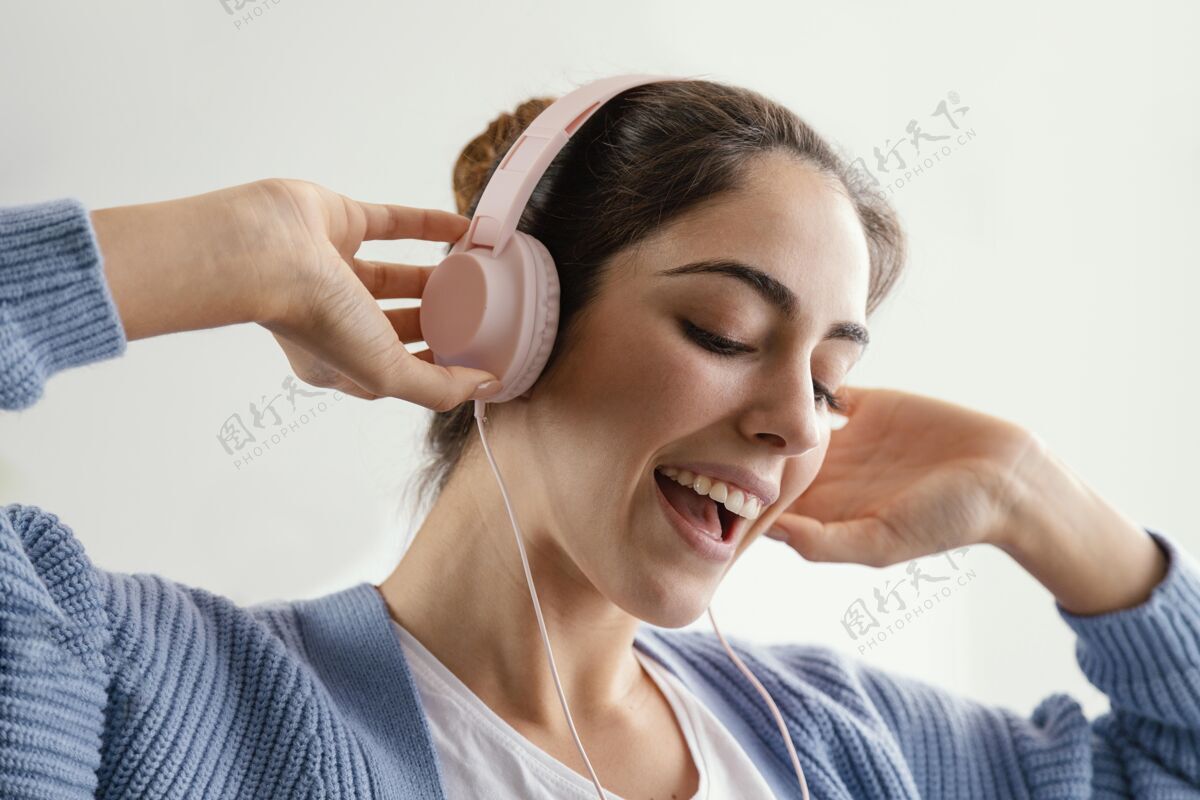 假期戴着耳机听音乐的笑脸女人房子室内家庭