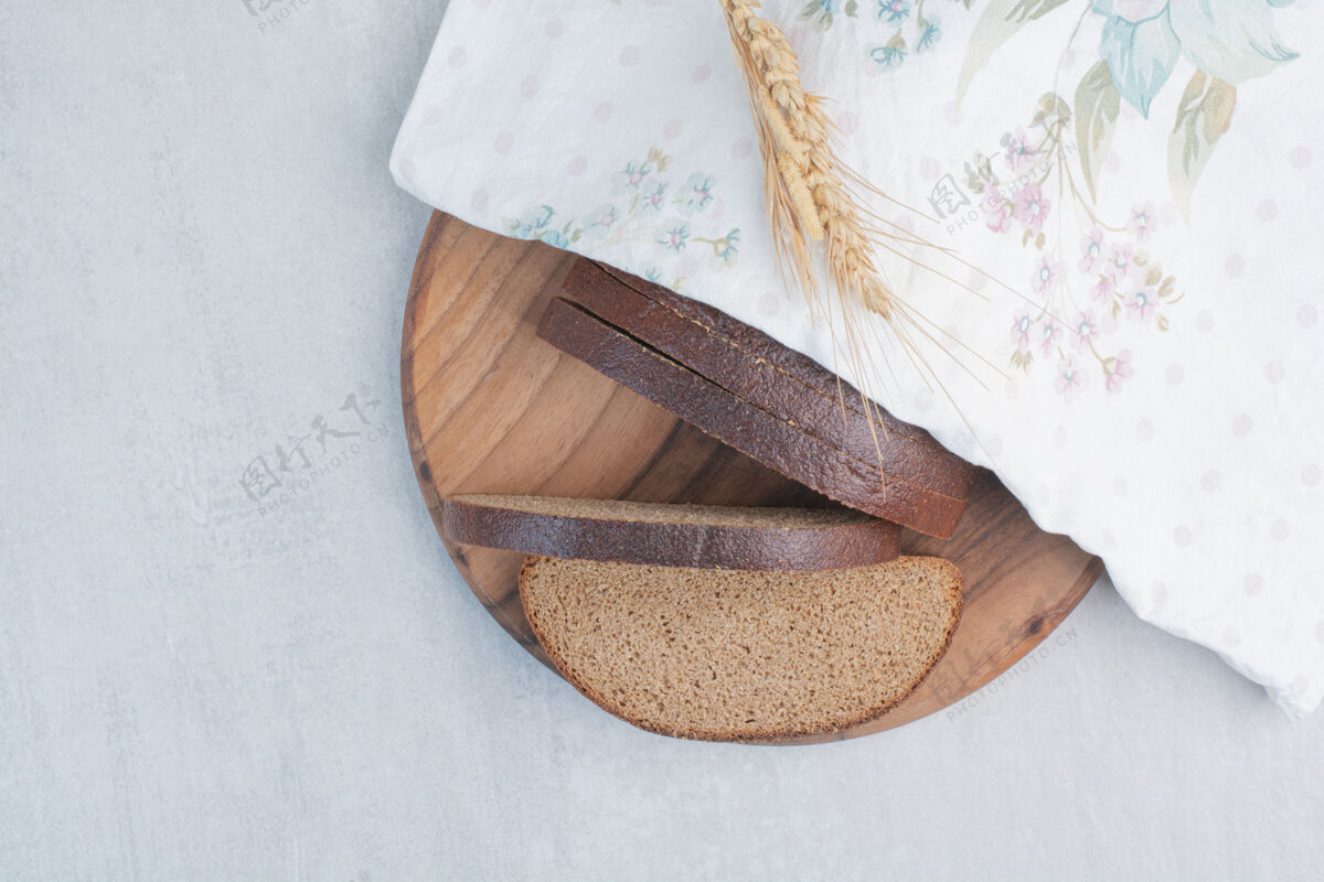面包把新鲜的棕色面包片放在桌布上新鲜面包切片食品