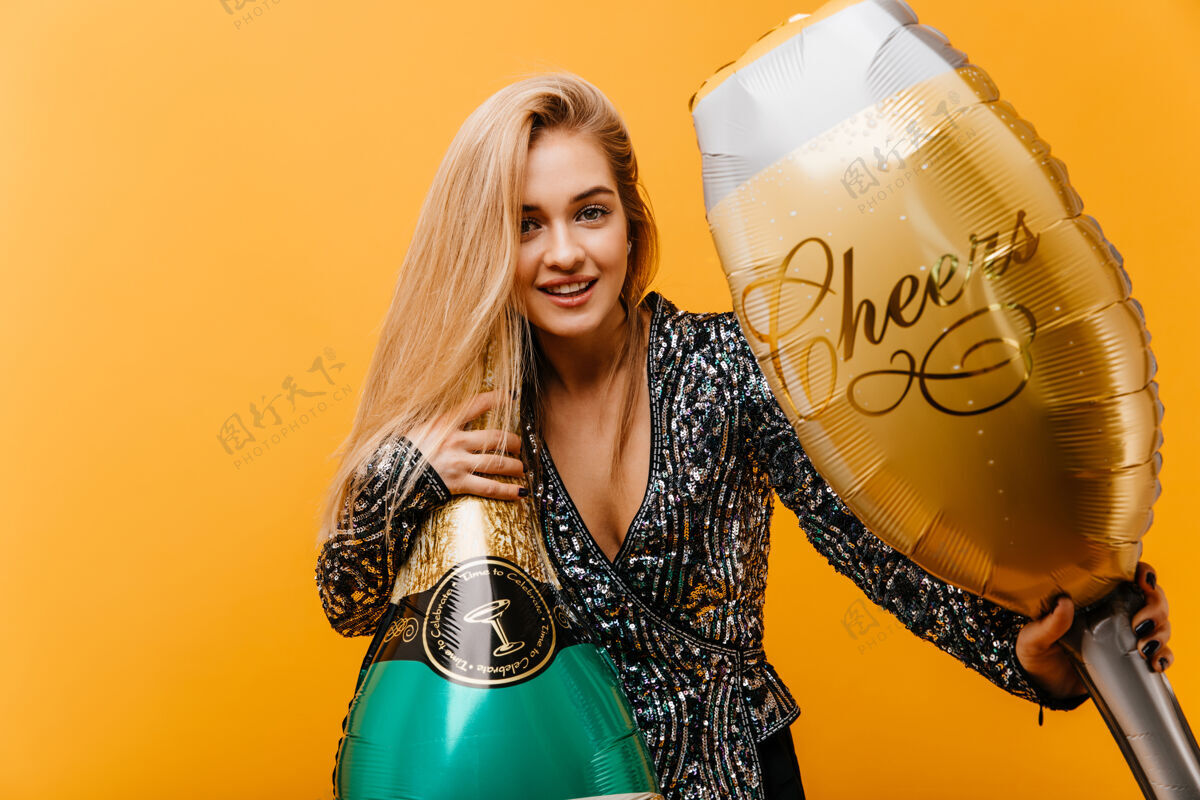 乐趣金发迷人的女人拿着一瓶香槟幸福的白人女人微笑着准备生日派对派对饮料优雅