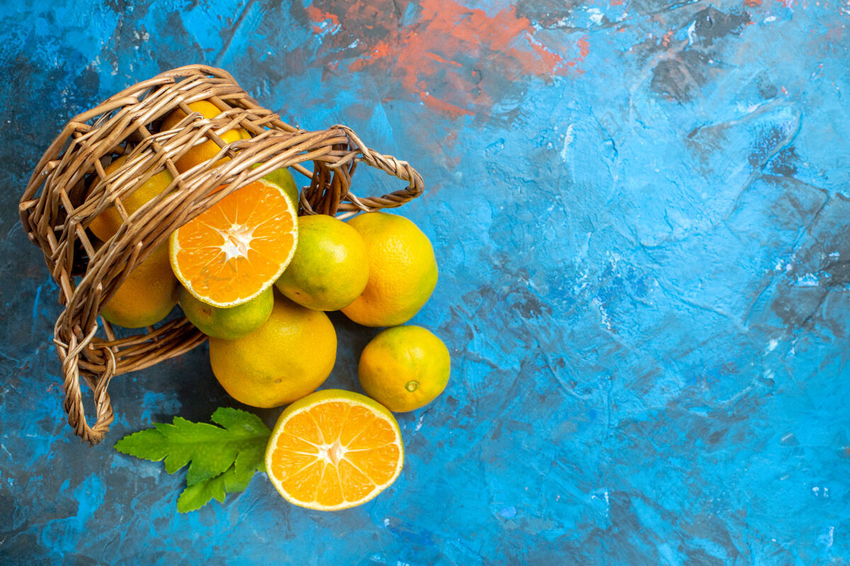 篮子顶视图新鲜柑桔柳条篮子上的蓝色表面自由空间维生素多汁观点
