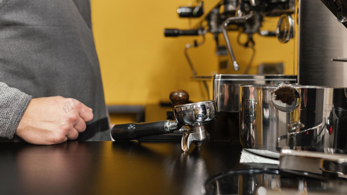 职业咖啡机旁有围裙的男咖啡师侧视图咖啡师水平服务员