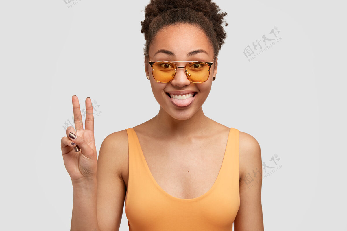 时尚搞笑正面黑人女模特秀舌头和平招牌舌头手照片