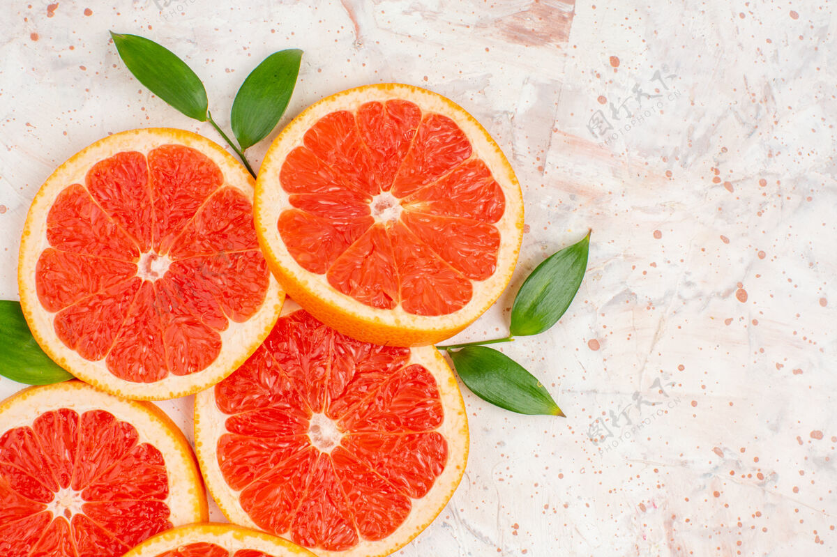 叶俯视葡萄柚片与叶片上的裸体表面自由的地方切片柑橘果汁