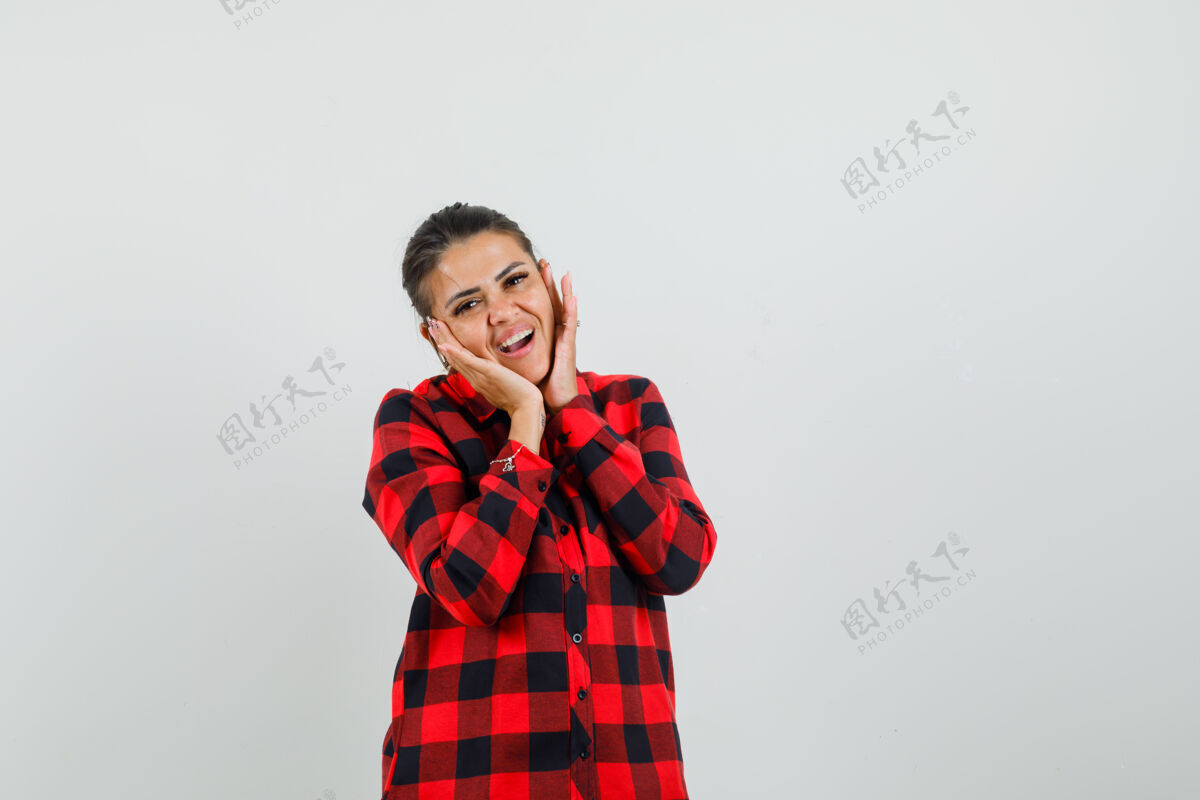 微笑穿着格子衬衫的年轻女子双手枕着脸 看起来很可爱正视图前面手快乐