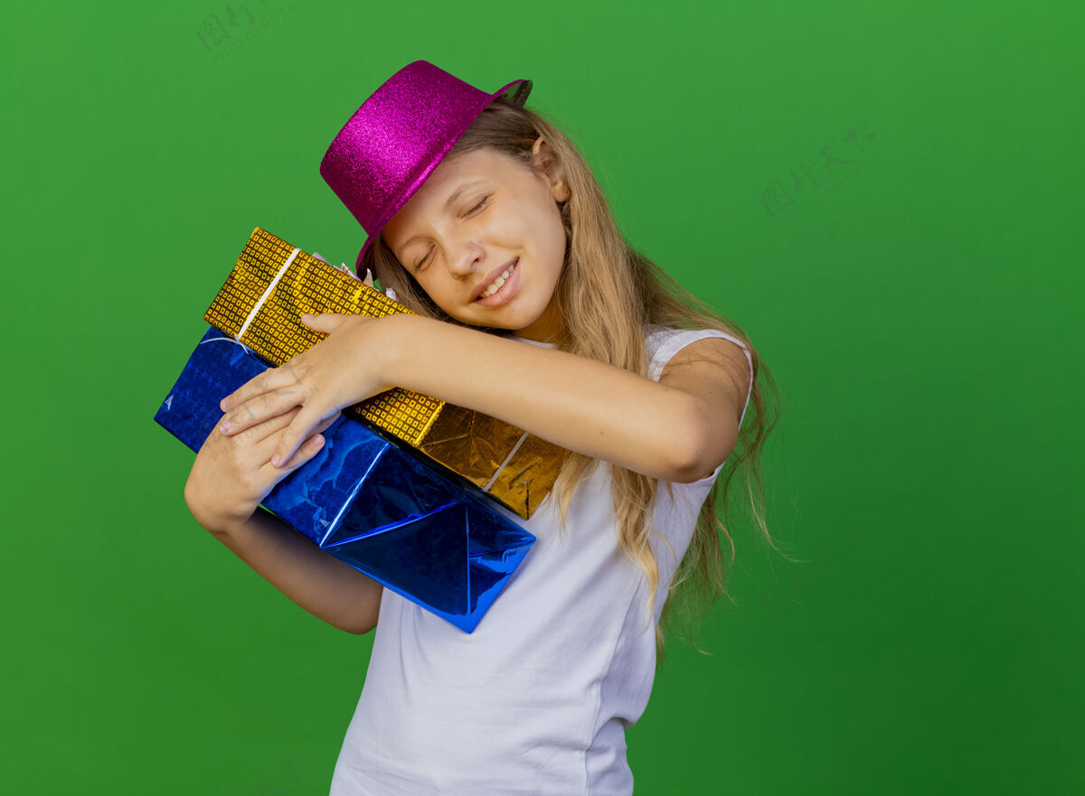 礼物戴着节日帽子拿着礼品盒的漂亮小女孩微笑女孩节日