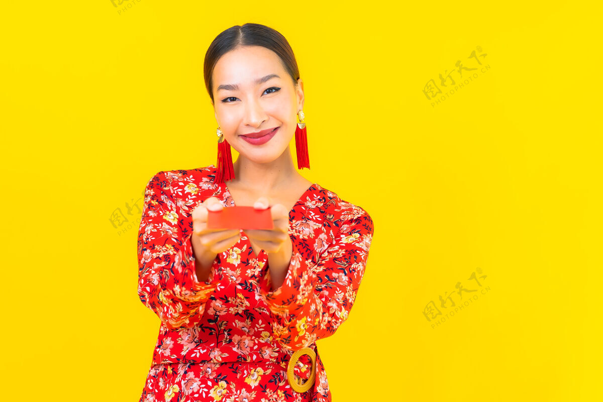 历史在黄色的墙上画一幅美丽的亚洲年轻女子拿着红包金融红包长相