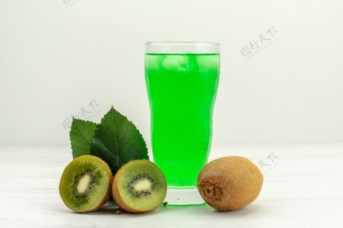 聚会正面图绿色猕猴桃汁和白色表面上的新鲜猕猴桃杯子果汁新鲜