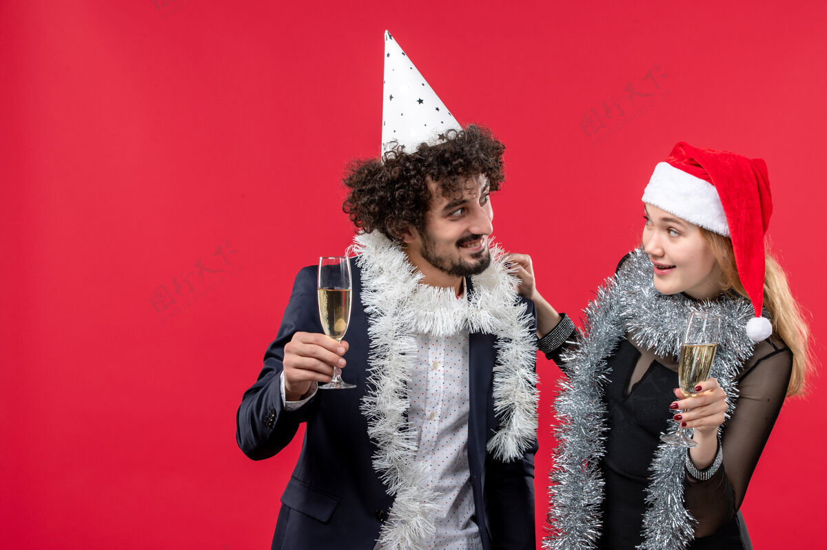庆典前视图年轻夫妇庆祝新年的红墙假日爱情圣诞晚会黑发成人羽毛宝儿