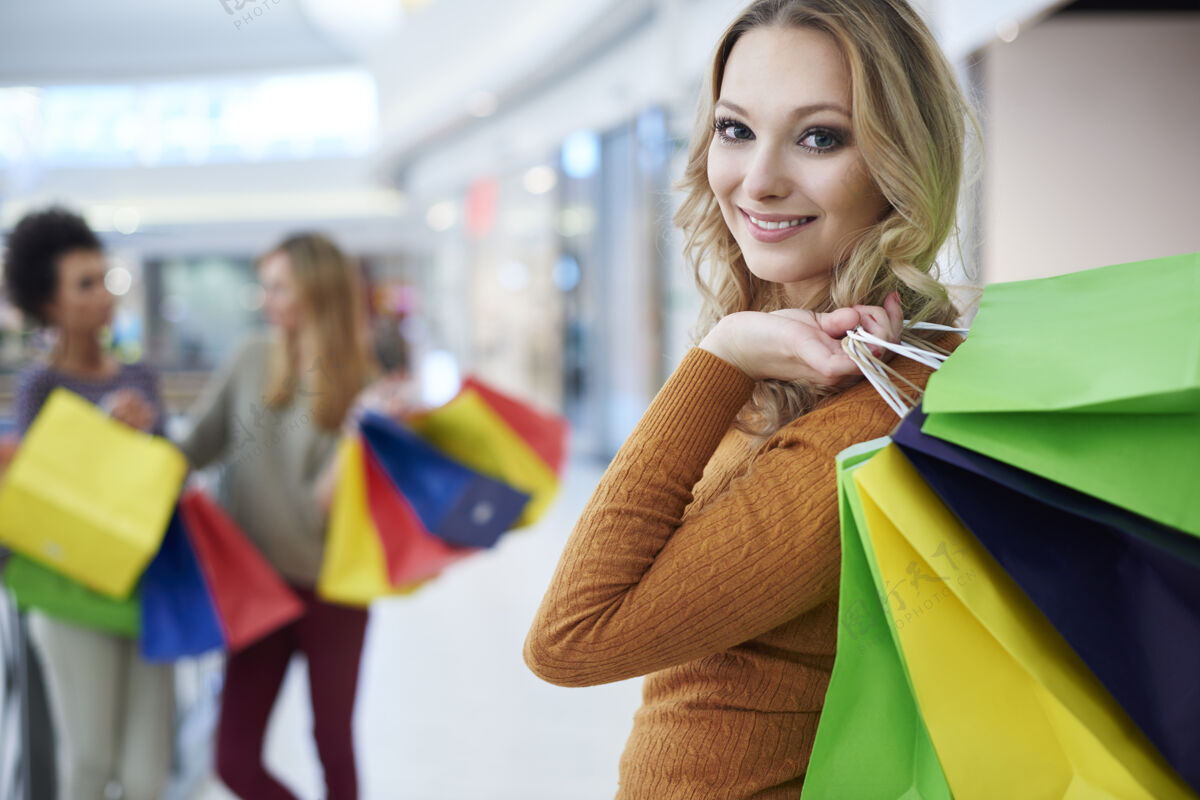 购物袋拿着购物袋的金发女人街头风格金发背景