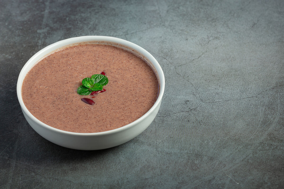 收获红豆热汤在白碗里放在黑暗的地板上香料种子生的