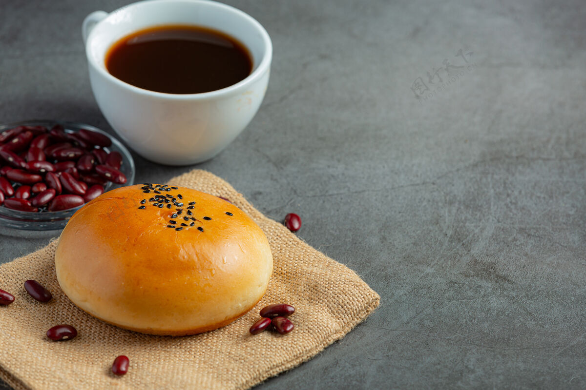 甜烤红豆沙包放在棕色布料上 配咖啡豆类蔬菜健康食品