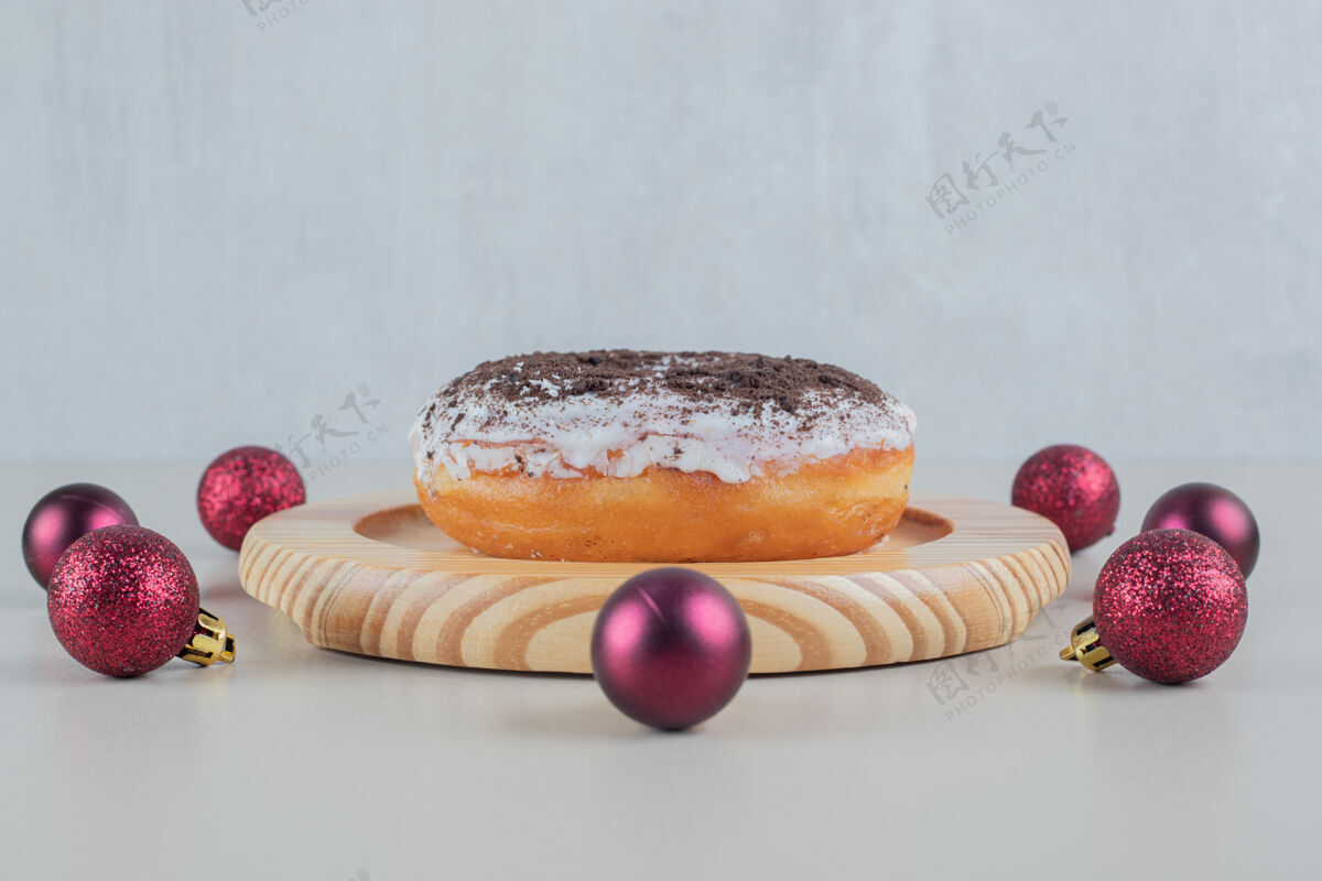 小吃巧克力甜甜圈和圣诞球洒球五颜六色
