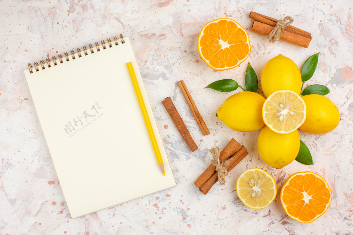 观点顶视图新鲜柠檬切橙色肉桂棒黄色铅笔笔记本上明亮的孤立的表面果汁切割笔记本