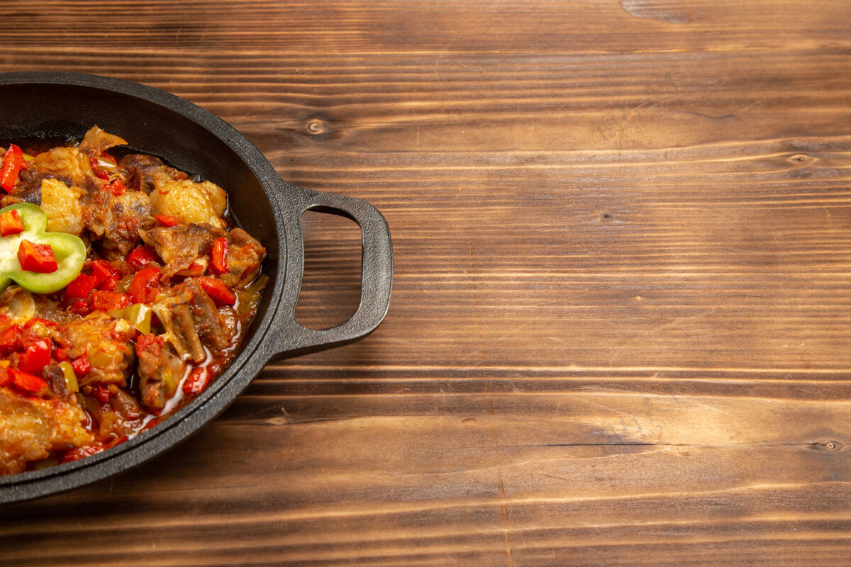 烹饪前视图煮熟的蔬菜饭在棕色的木头表面锅里饭食物胡椒