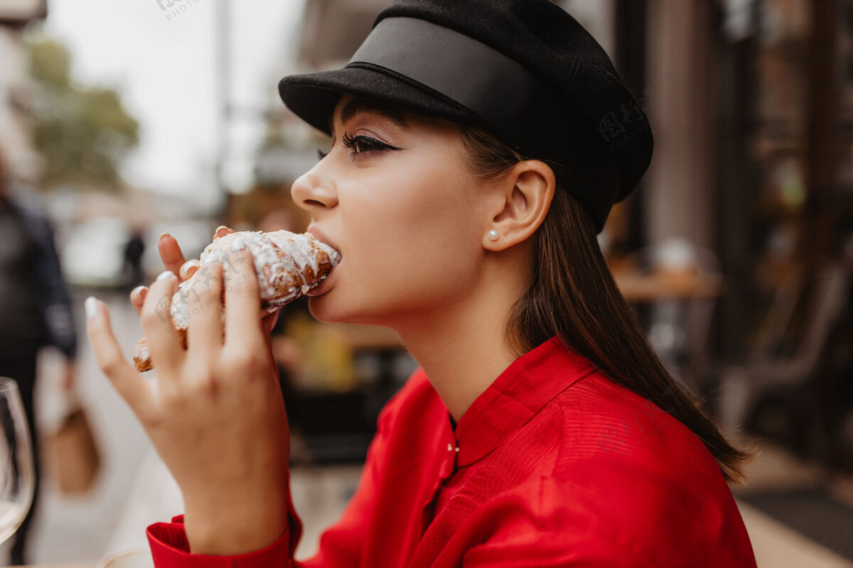 法国身着贝雷帽的棕色头发的漂亮女孩的资料照片在街边咖啡馆品尝著名美国甜点的女人成人精致瘦身