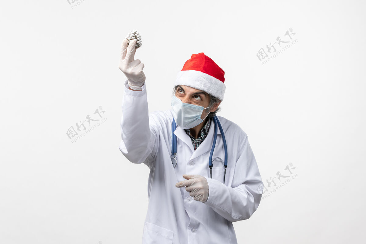 药品正面图男医生用新年树玩具上白墙病毒健康共价外套医院医生