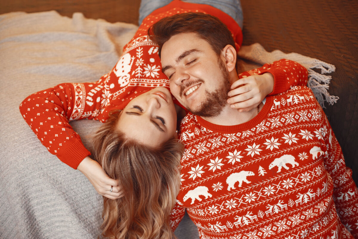 浪漫人们在圣诞节装饰男人和女人在红色毛衣惊喜男性装饰