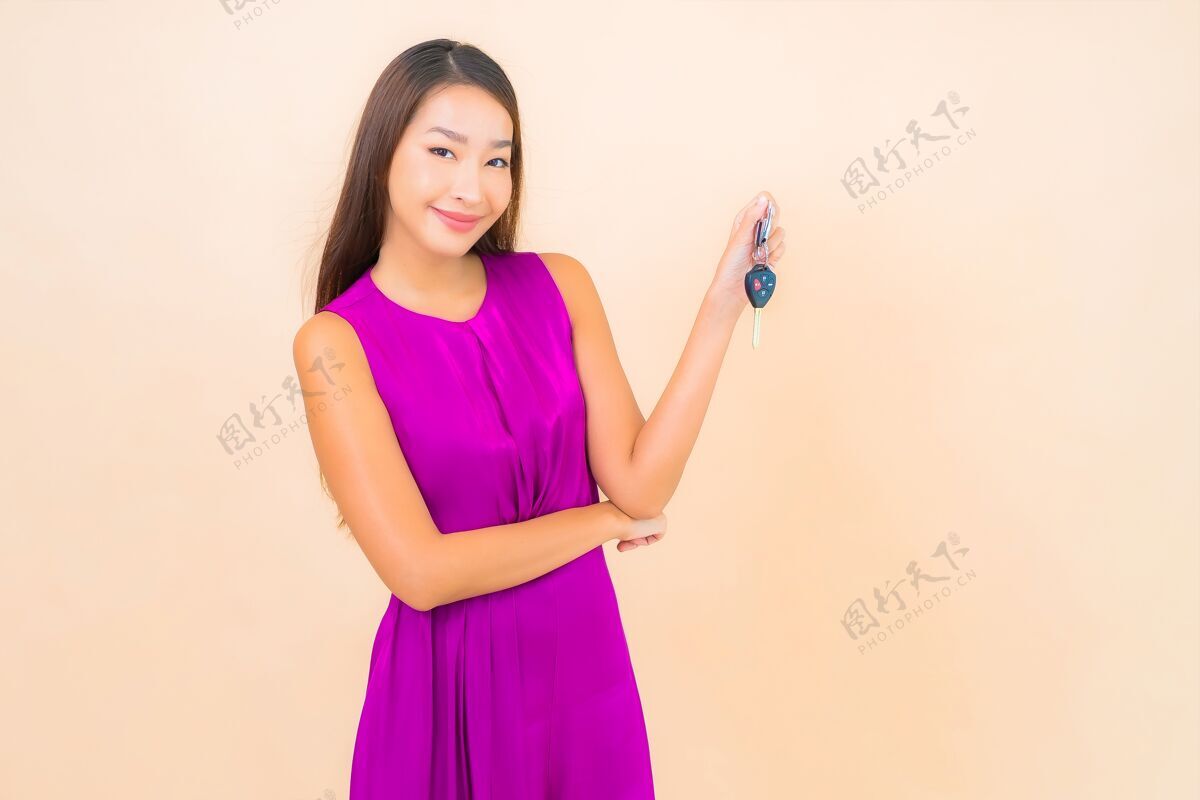 业主肖像美丽的亚洲年轻女子与汽车钥匙的颜色隔离的背景肖像旅行汽车