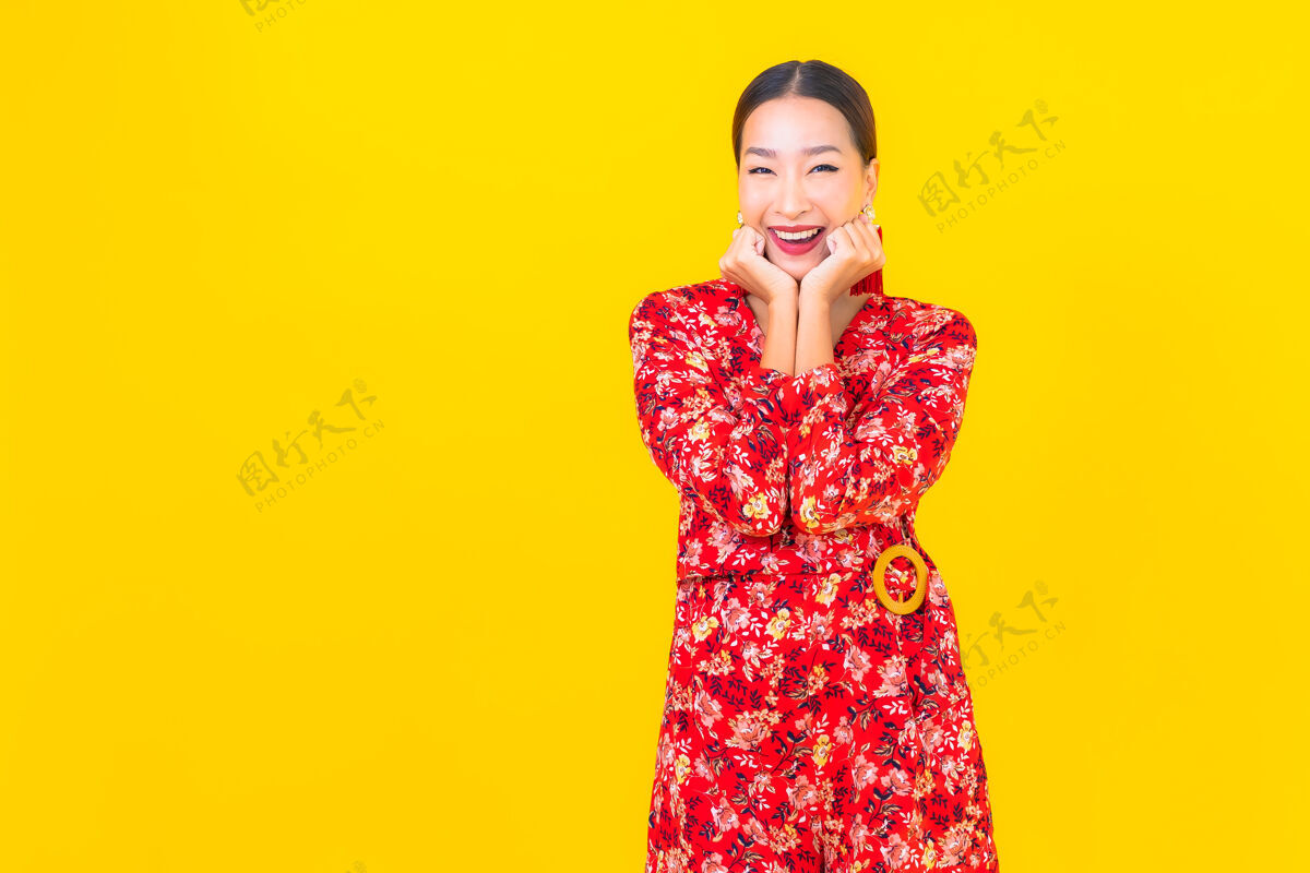 文化美丽的亚洲年轻女子在彩色墙上的中国新年概念中的微笑手势女性观点
