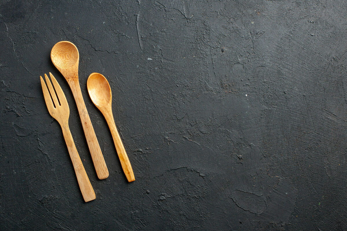 食物顶视图木制叉子和勺子在黑暗的桌子上与自由的地方地方厨房勺子