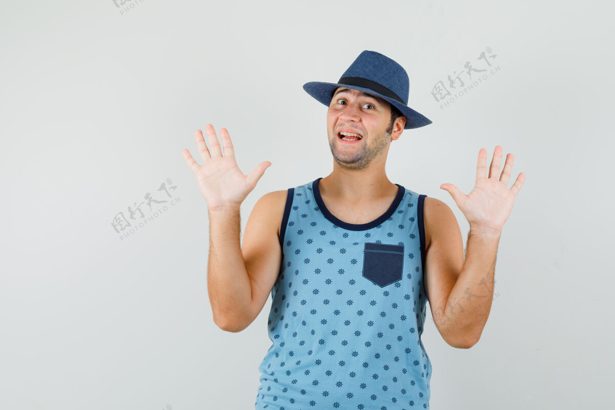 手掌一个穿着蓝色单品的年轻人 戴着一顶呈投降姿态的手掌的帽子 看上去很可爱单身胡茬展示