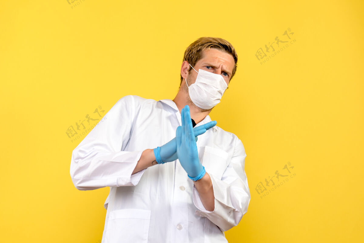医学正面图男性医生在黄色背景大流行性冠状病毒-健康病毒上显示禁止标志医院听诊器人