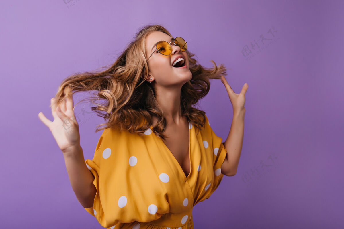 爱可爱的欧洲女人在紫罗兰上嬉戏时髦的棕褐色女孩在玩她的金色波浪发淑女优雅年轻
