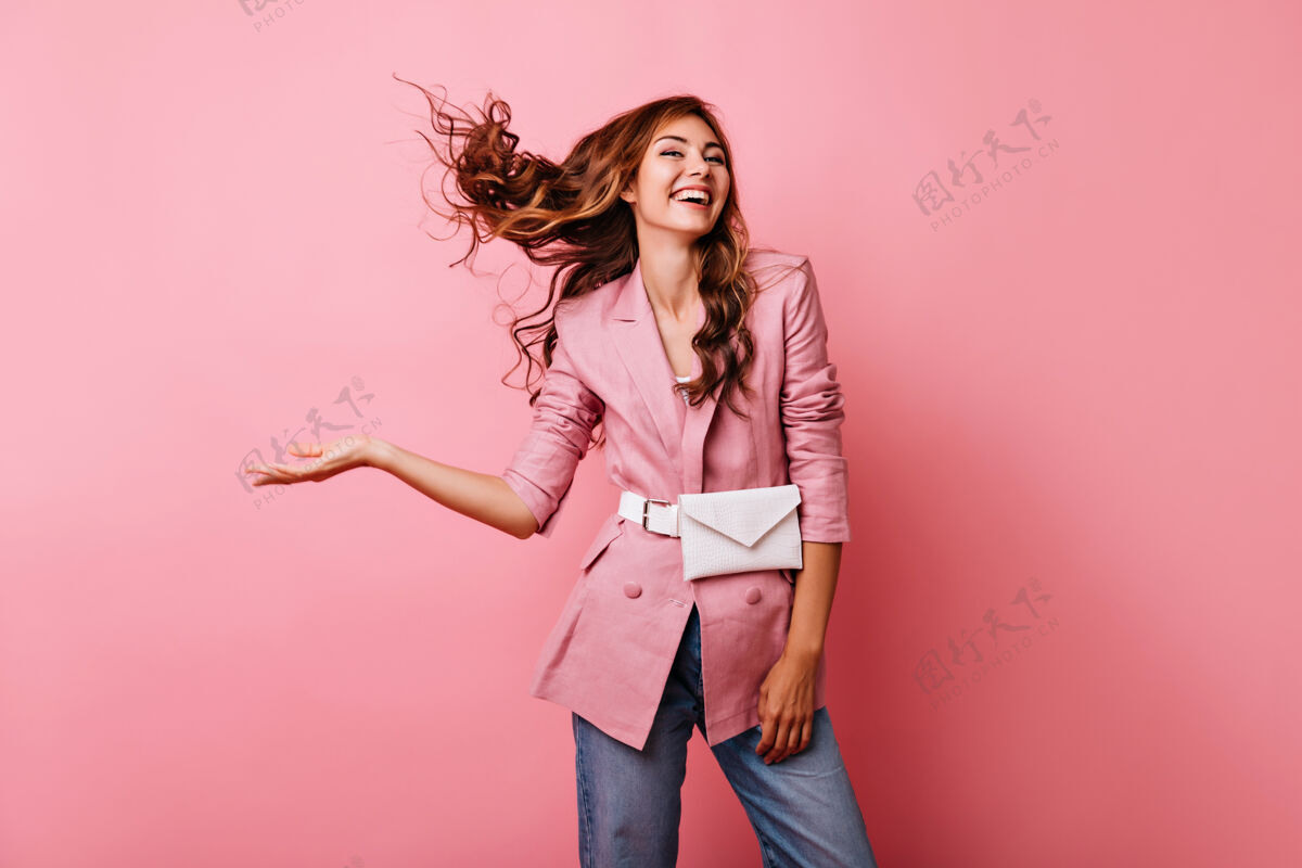 舞蹈幸福的红发女孩享受着写真拍摄无忧无虑的高加索女士穿着粉色夹克 笑着粉彩人积极服装
