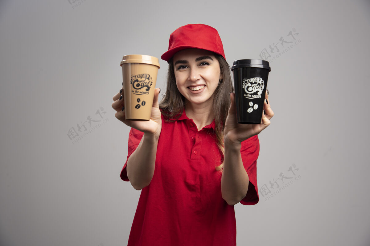 快递穿着红色制服拿着咖啡杯的女送货员饮料女人事业