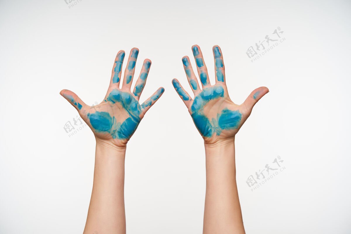 女士皮肤白皙的女性手的肖像 上面涂有蓝色颜料 显示手掌 保持所有手指分开 被隔离在白色上手掌展示情绪