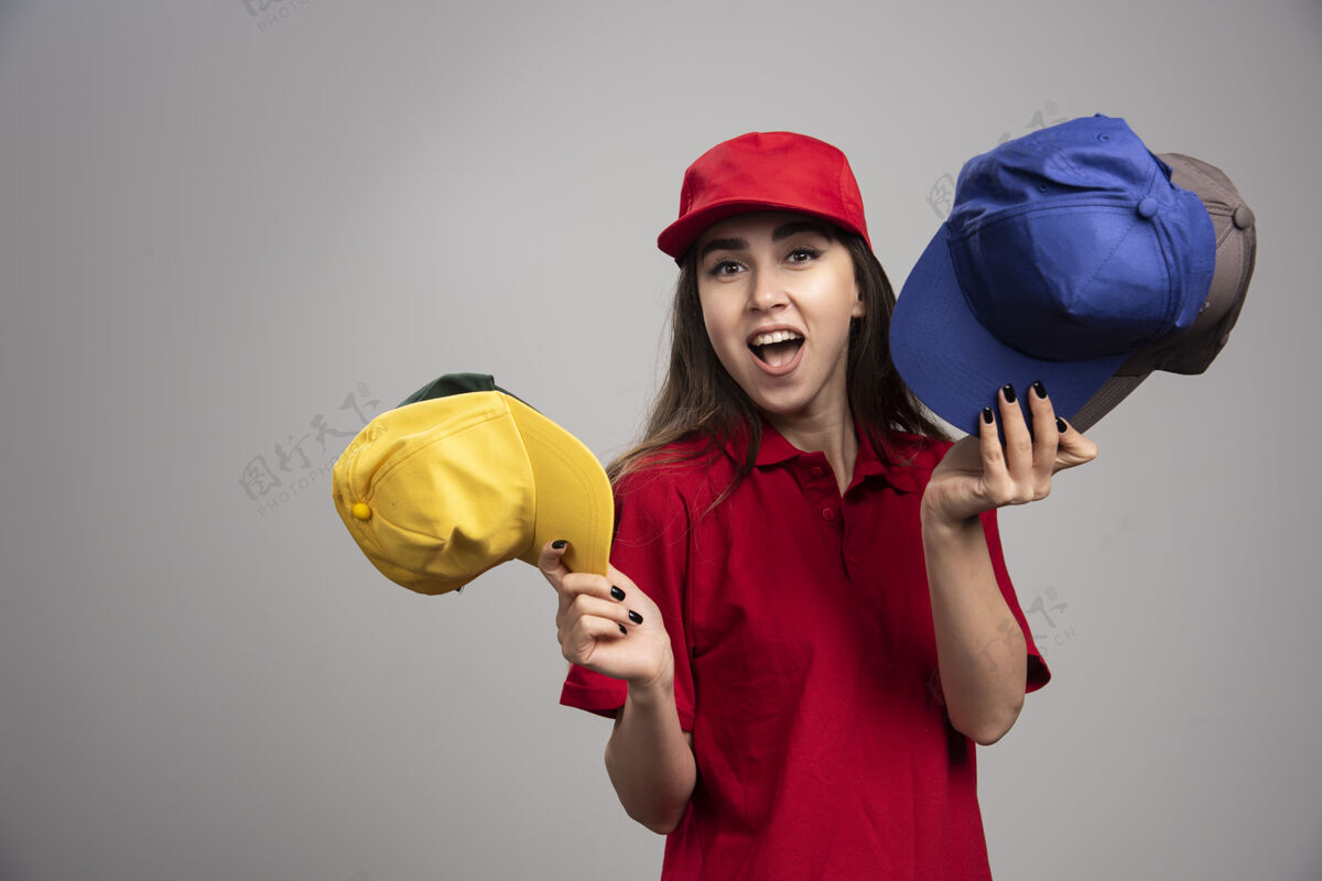 帽子一个穿着红色制服 戴着彩色帽子的送货员承运人女雇员