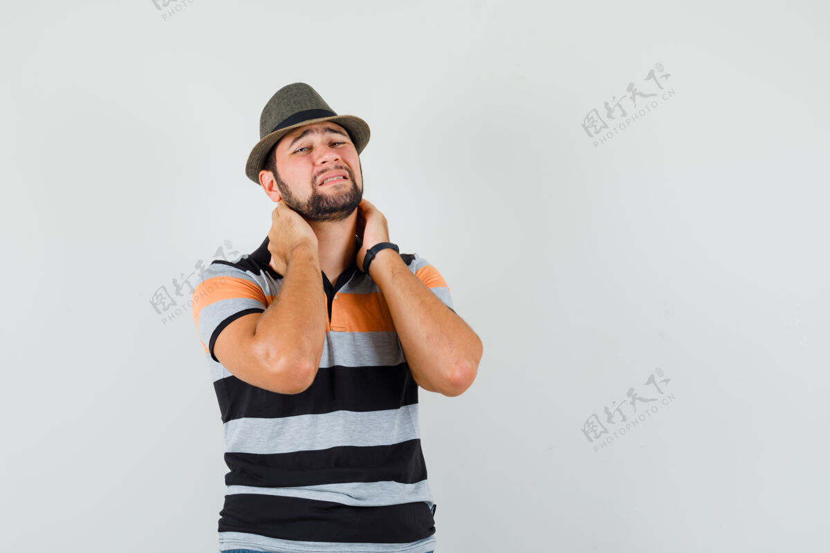 成功年轻人脖子疼 穿着t恤 戴着帽子 看上去很烦躁现代男人T恤