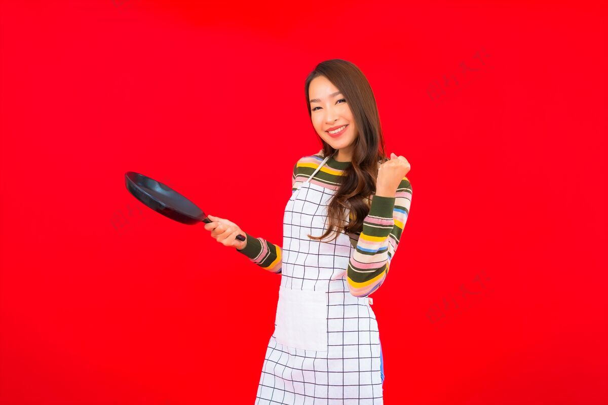 板画像美丽的亚洲年轻女子拿着锅准备在红墙上做饭年轻炉子快乐