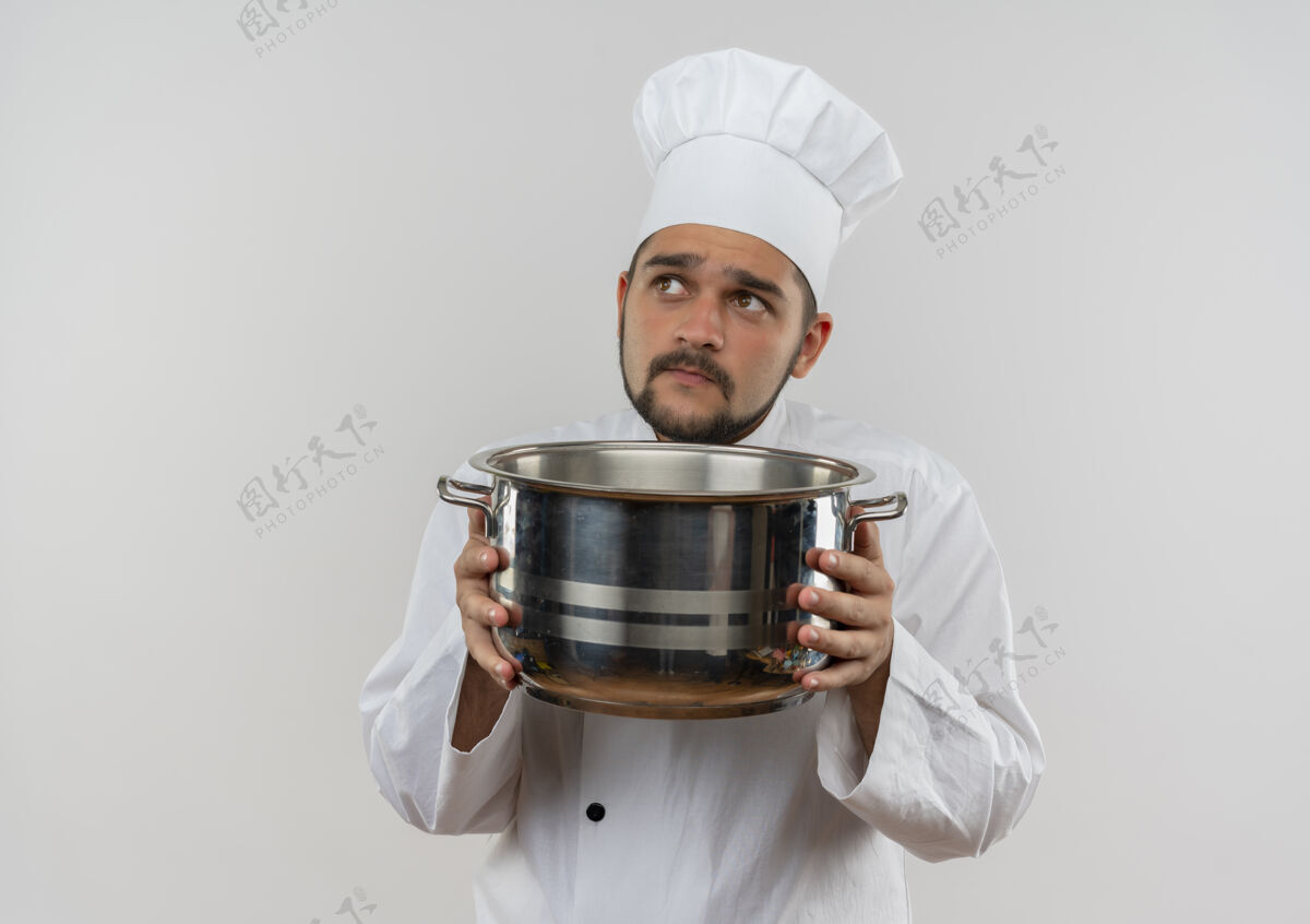 想体贴的年轻男厨师 身着厨师制服 手拿锅碗瓢盆 孤零零地仰望着白色的空间抱着看着厨师