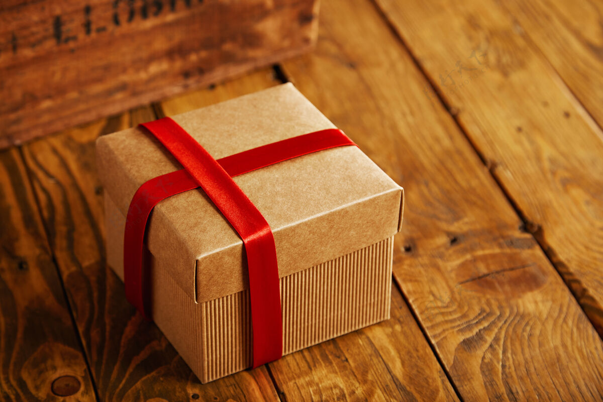 信件集中方形纸板箱关闭 并用红丝带包裹在古董板条箱旁边的乡村木桌上包裹脏的盒子
