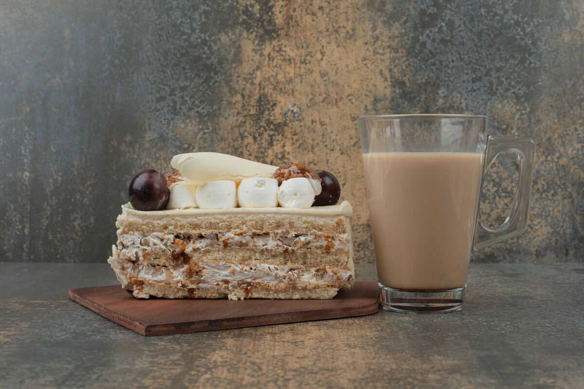 杯子在大理石墙上放一块蛋糕和一杯热咖啡可口可食用板