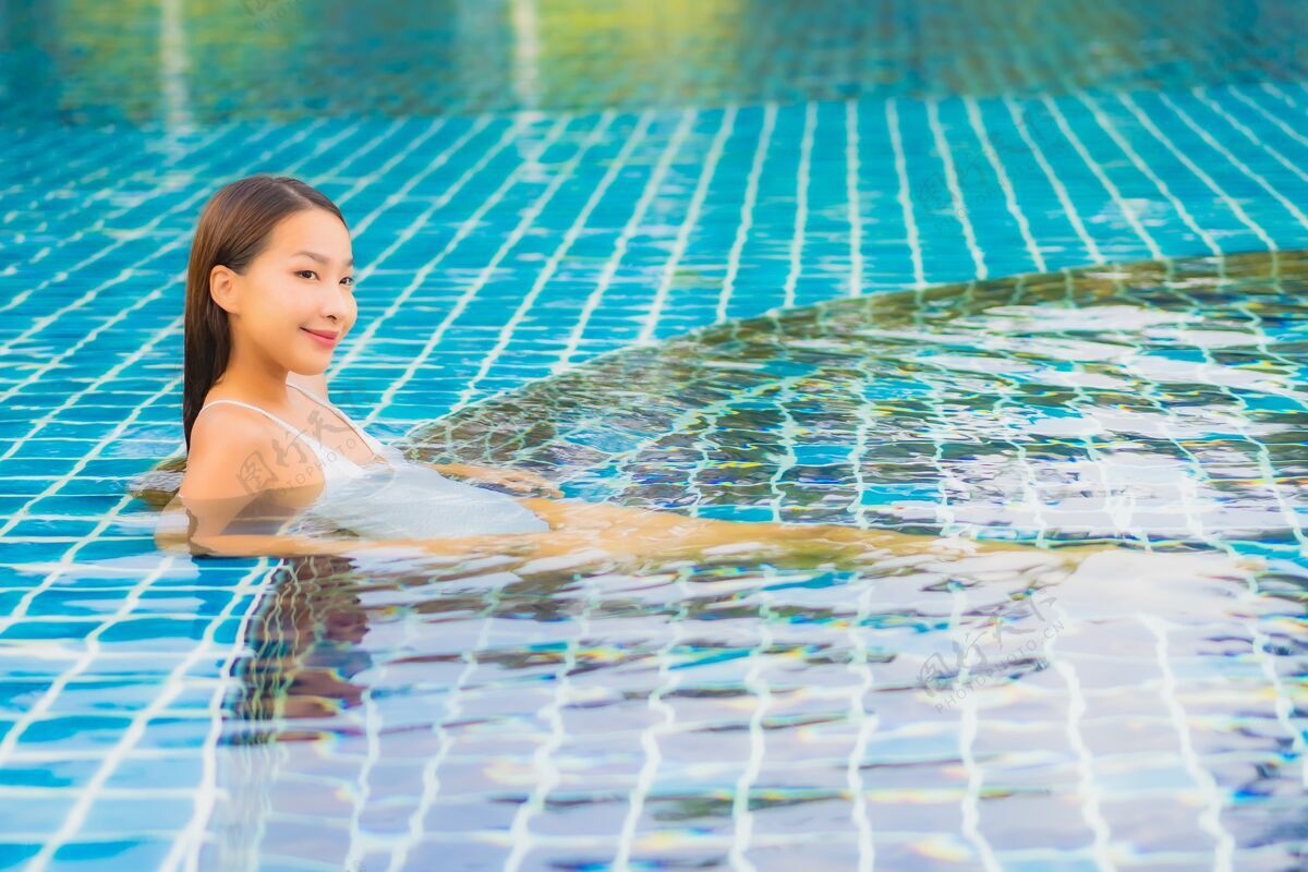 泳装肖像美丽的亚洲年轻女子放松微笑休闲围绕室外游泳池近海度假亚洲人豪华