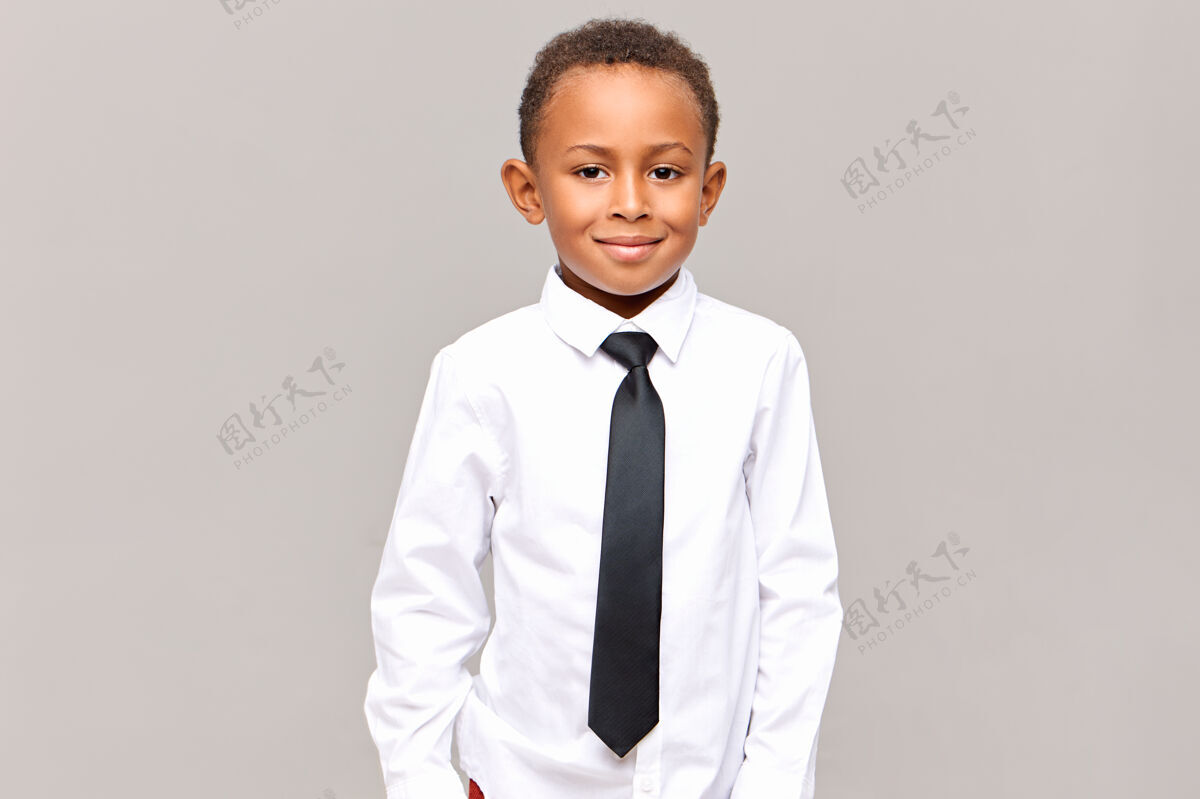 童年齐腰帅气整洁的黑皮肤男小学生摆出孤立的姿势 身着洁白的熨烫衬衫和黑色优雅的领带 准备上学 面带微笑小学生制服非洲