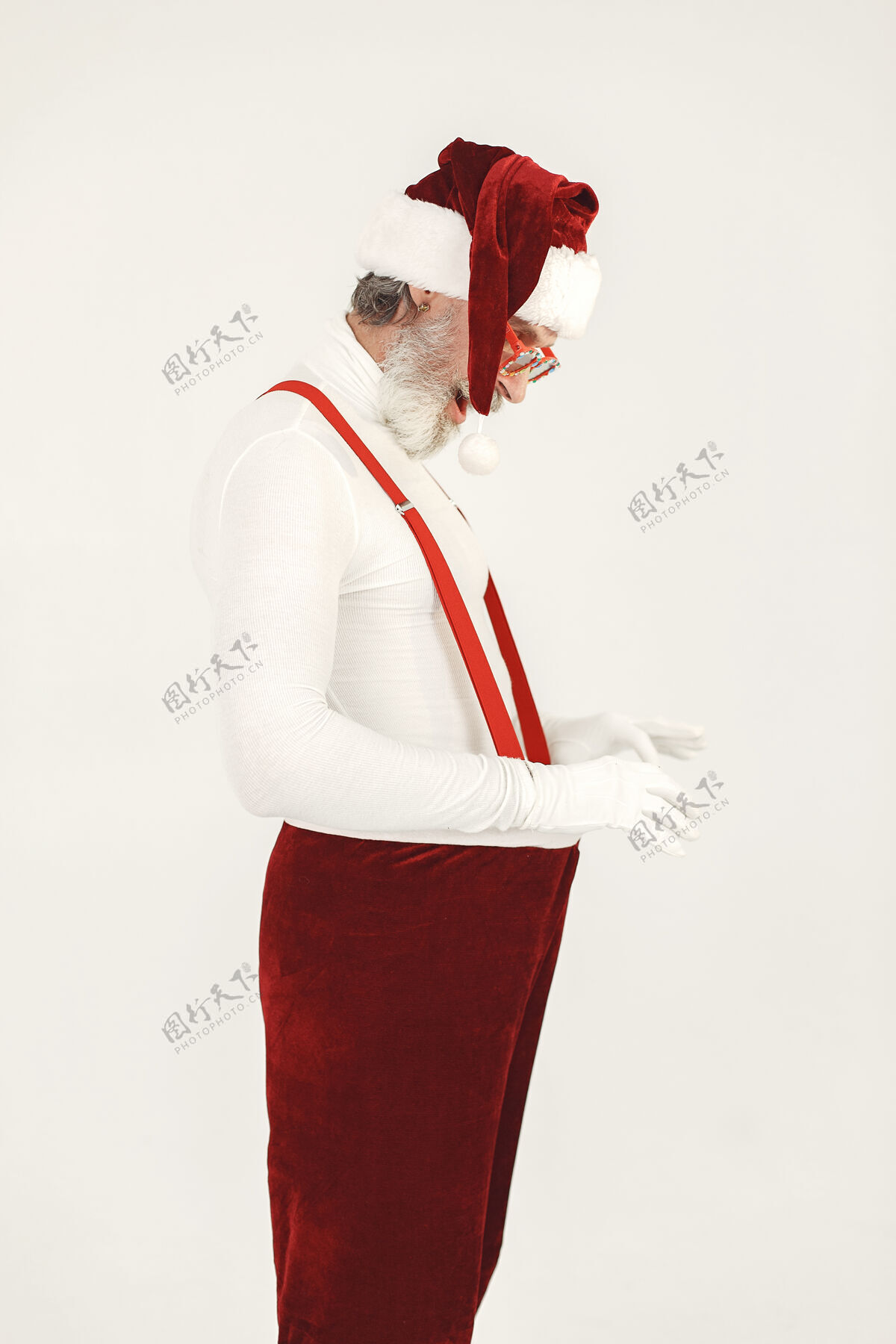 庆祝时髦的灰色头发的圣诞老人男人穿针织衣服爷爷戴着圣诞老人的帽子冬天祖父仙女