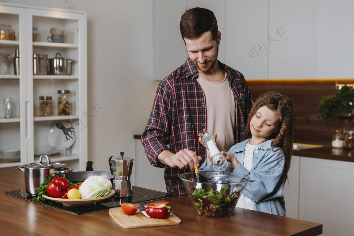 蔬菜父亲和女儿在厨房准备食物的正面图爸爸爸爸准备