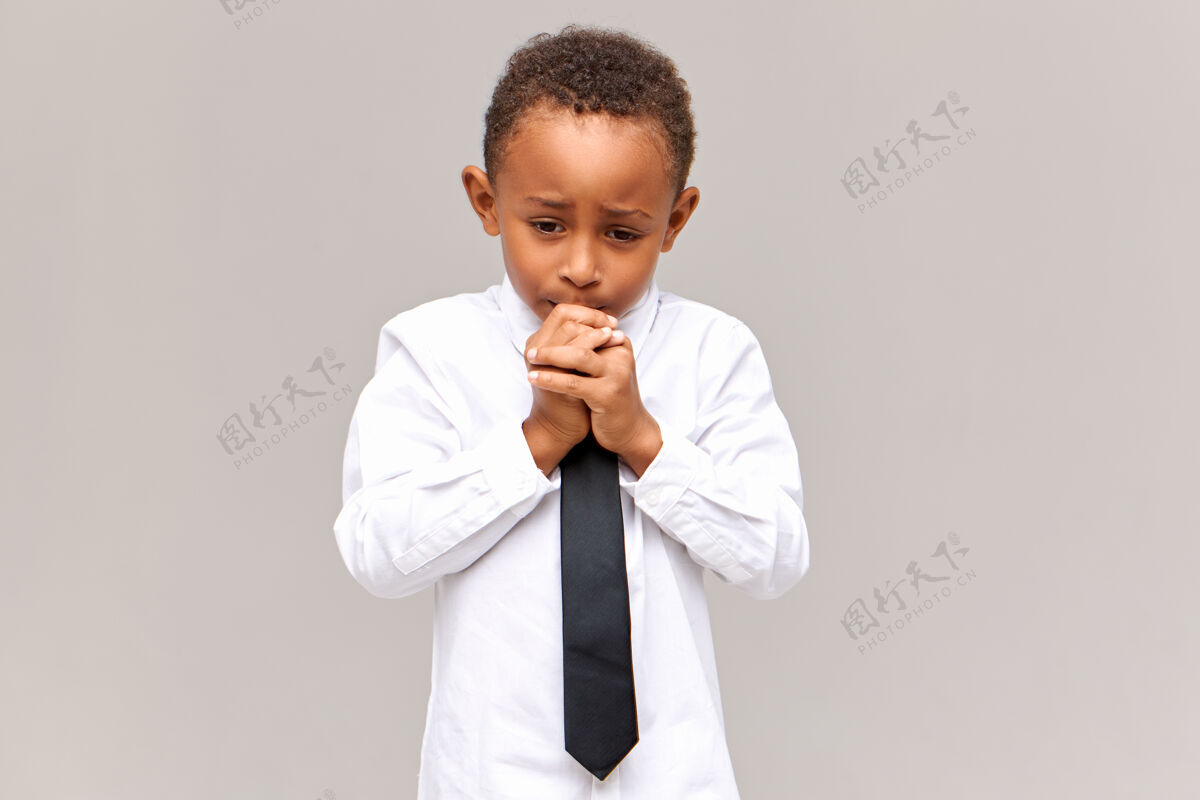 男孩一幅紧张 沮丧 悲伤的非洲裔美国小学生的画像 他穿着制服 神情焦虑 啃着指甲 害怕在学校因为成绩不好而被训斥真挚的情感童年孩子肖像