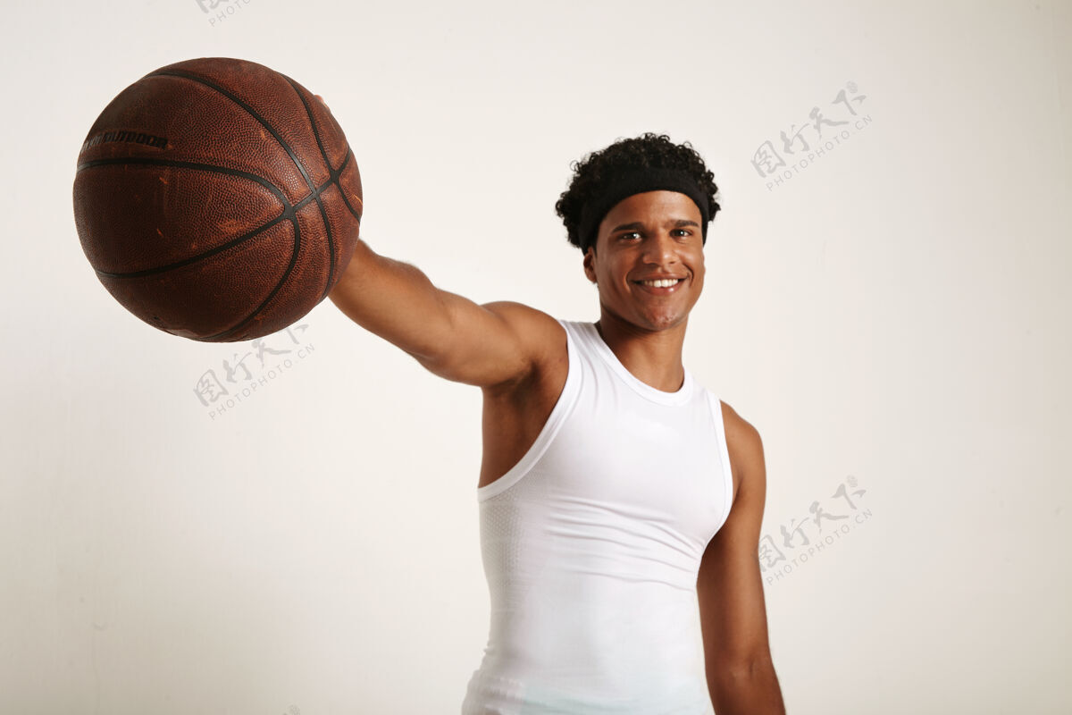 街球快乐微笑的年轻黑人运动员 身穿白衬衫 头上戴着非洲式头巾 手里拿着一个老式的棕色篮球爱好黑色棕色