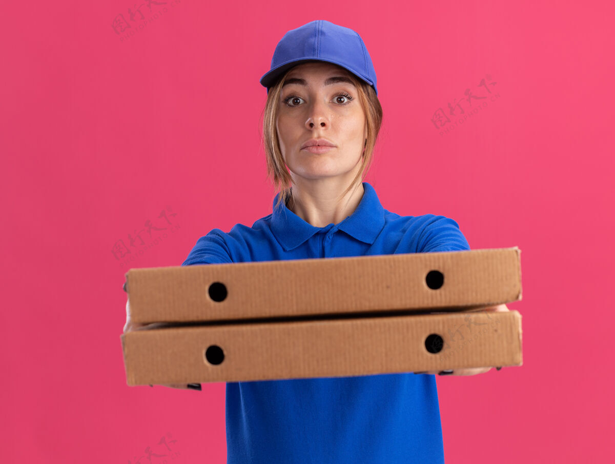 持有自信的年轻漂亮的女送货员穿着制服孤立地拿着比萨饼盒制服年轻人食物