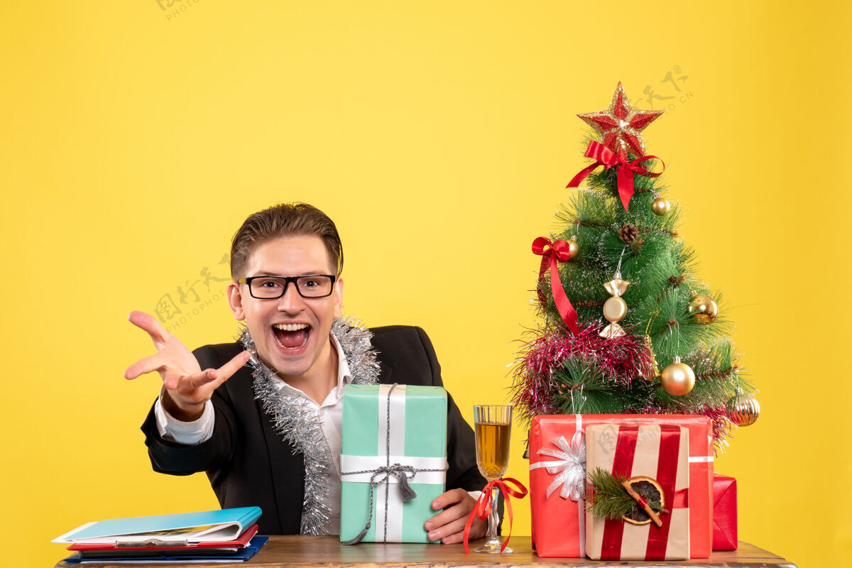 礼物正面图：男工人拿着圣诞礼物和圣诞树坐着生活艺人坐