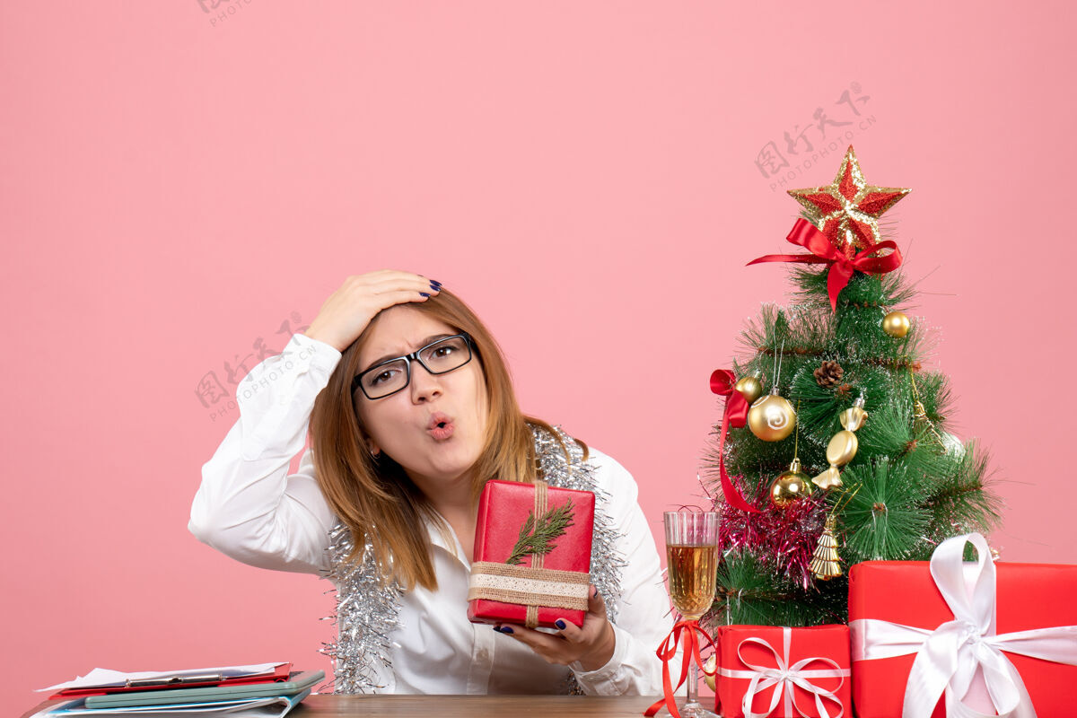 肖像女工正坐在粉红色的椅子上 手里拿着圣诞礼物粉色坐着成人