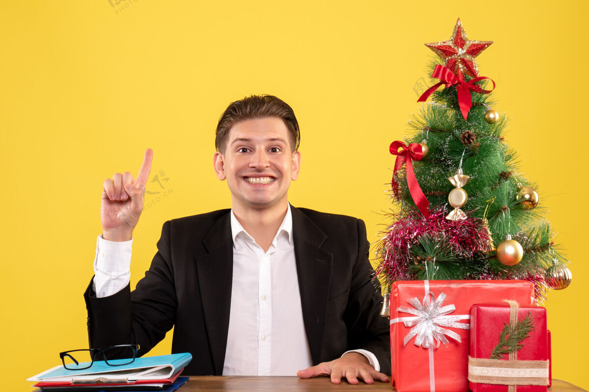 职业正面图：坐在工作台后面微笑的男工人新郎圣诞年份